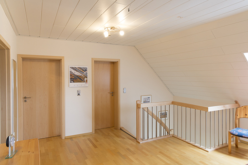 Der obere Flur wirkt mit den weißen Paneelen und dem hellen Holz gleich viel einladender