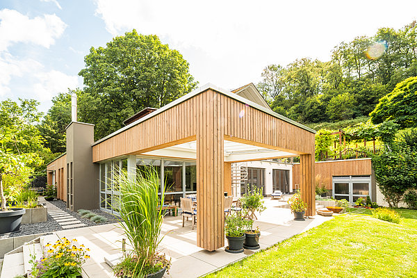Anbau mit moderner Holzfassade für zusätzlichen Wohnraum und überdachte Terrasse