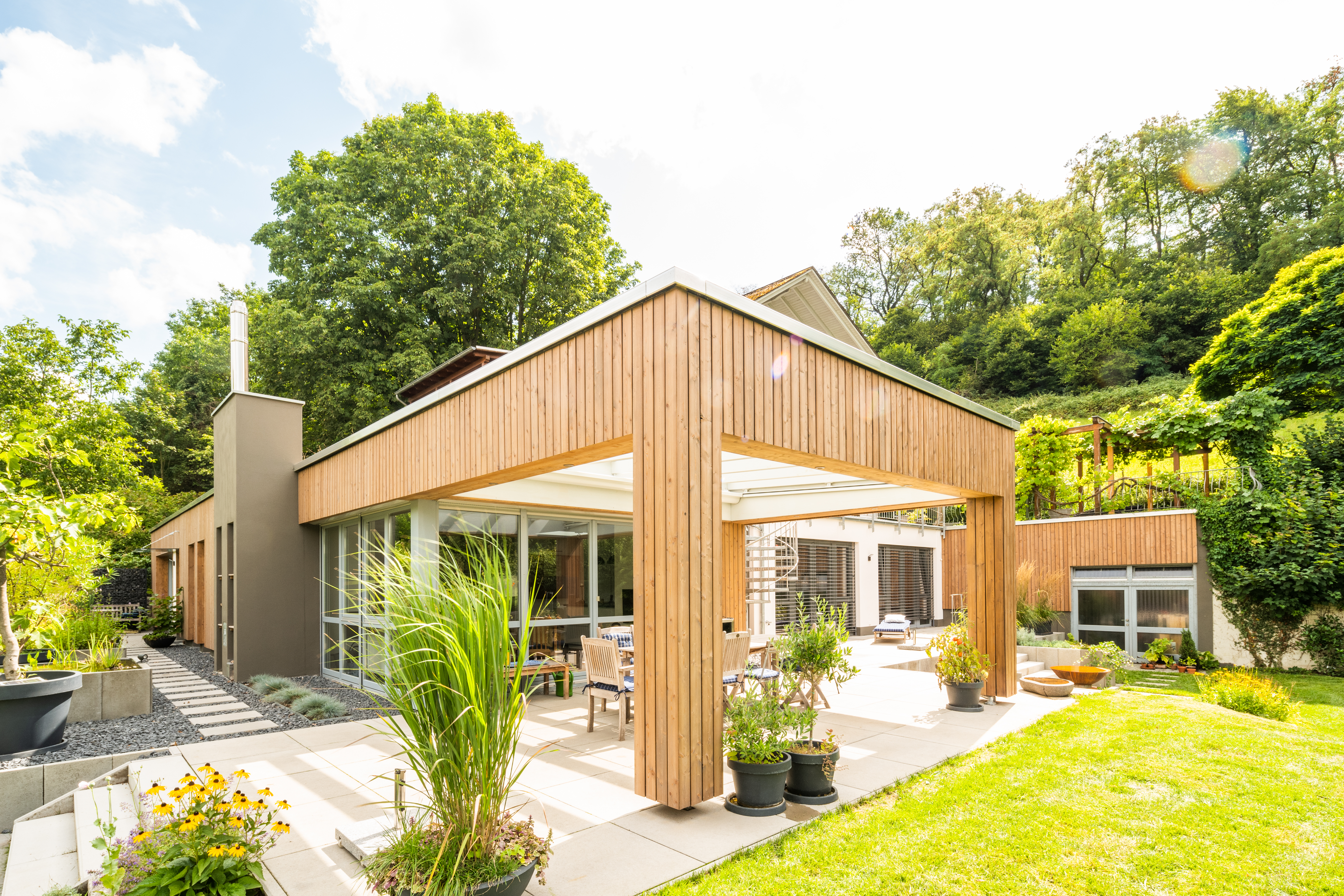 Anbau mit moderner Holzfassade für zusätzlichen Wohnraum und überdachte Terrasse
